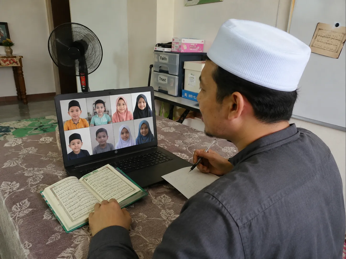 Guru lelaki sedang mengajar kelas Iqra berkumpulan secara online